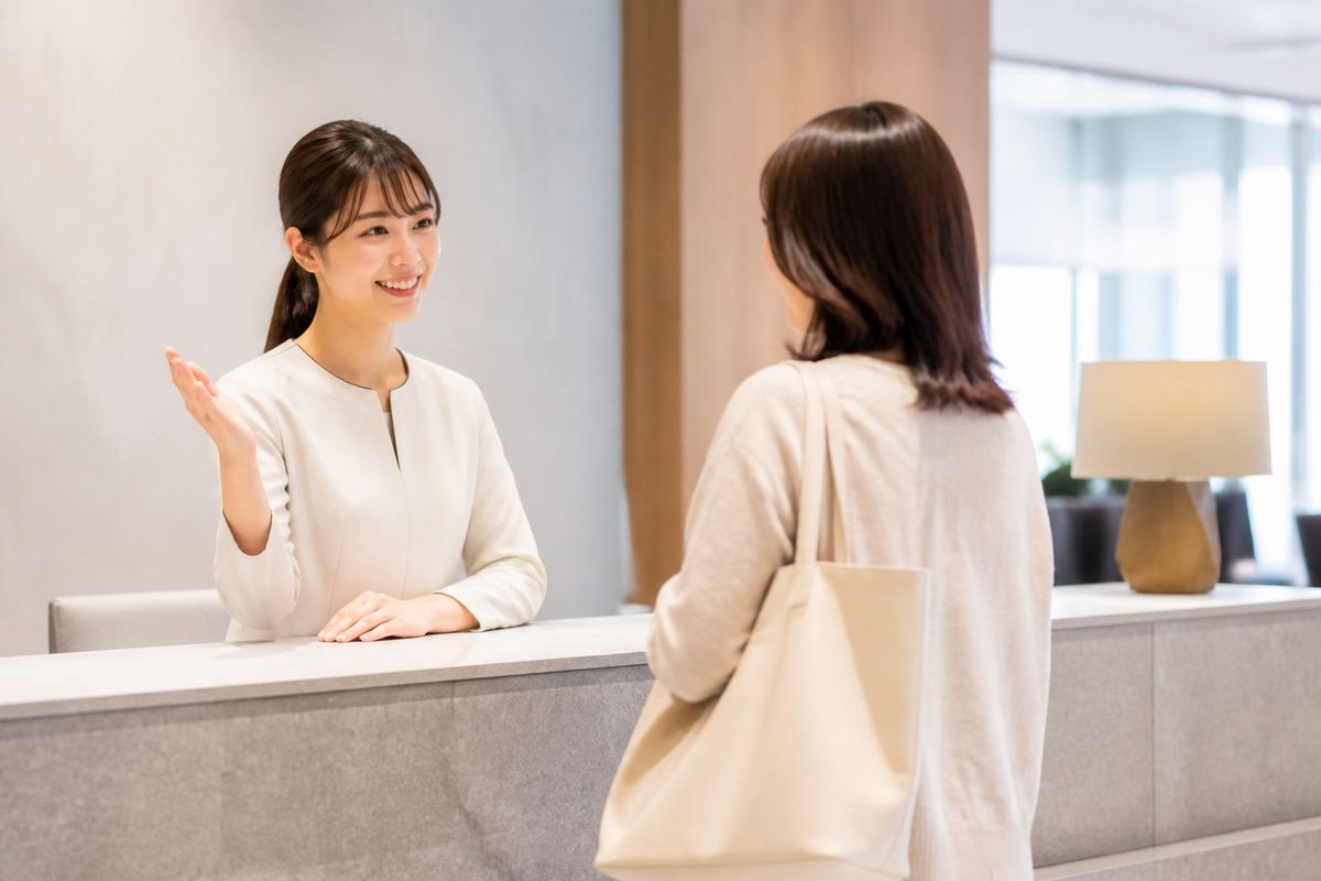 商業施設のインフォメーションカウンターでスタッフが来館者に案内している様子