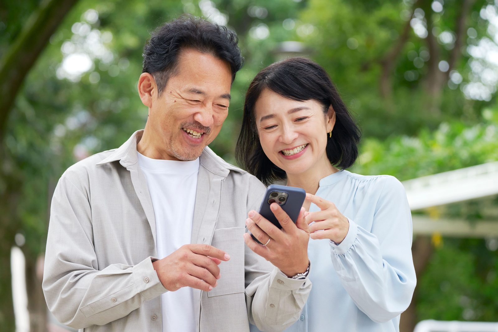 デジタルスタンプラリーにスマホで参加し、画面を見て笑顔になっている参加者