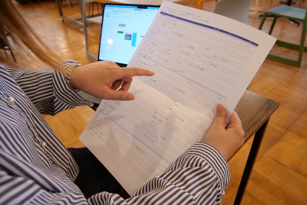 印刷した資料の内容を指でたどって確認する様子