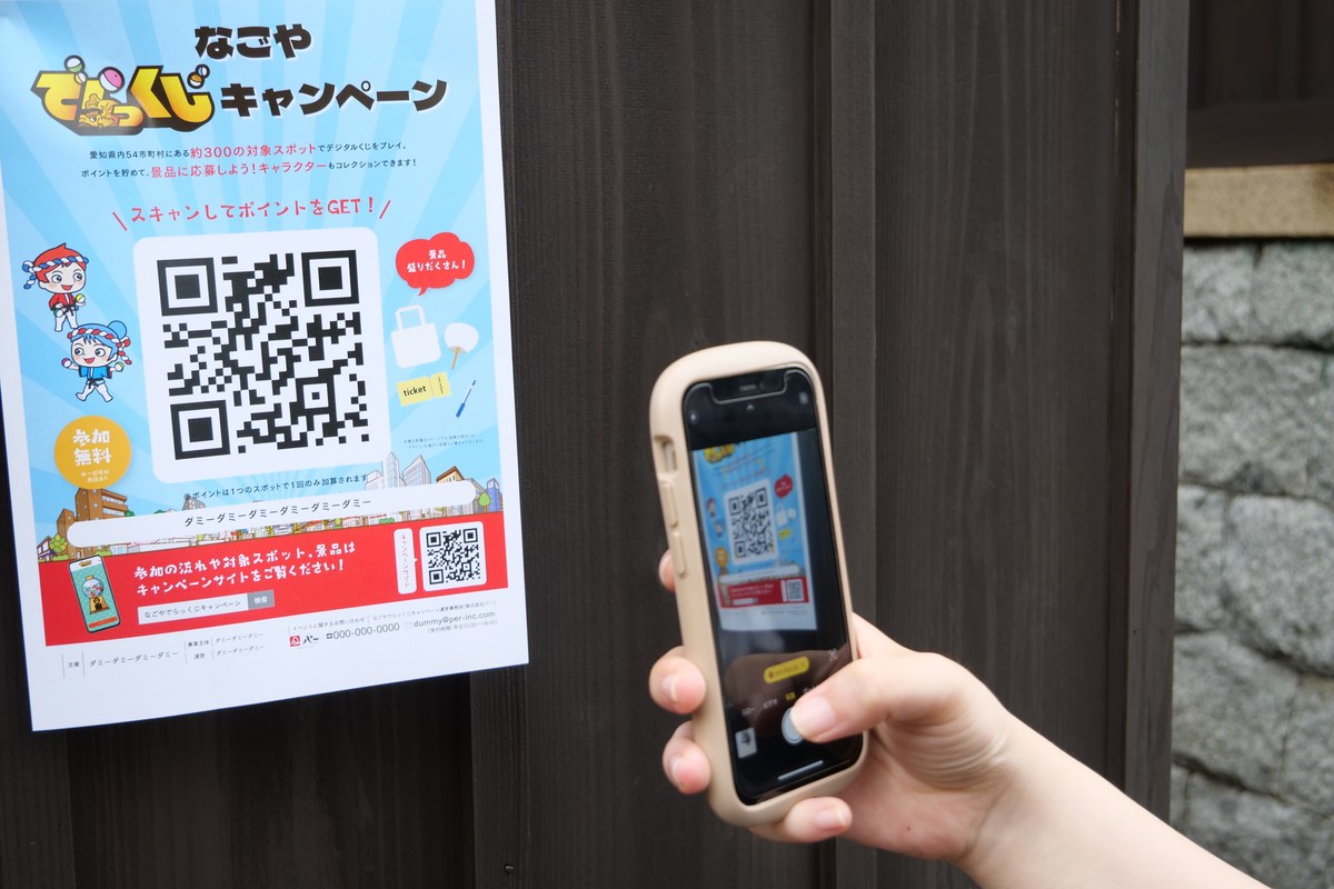店頭に貼られたQRコードのポスターをスマートフォンで読み取る様子