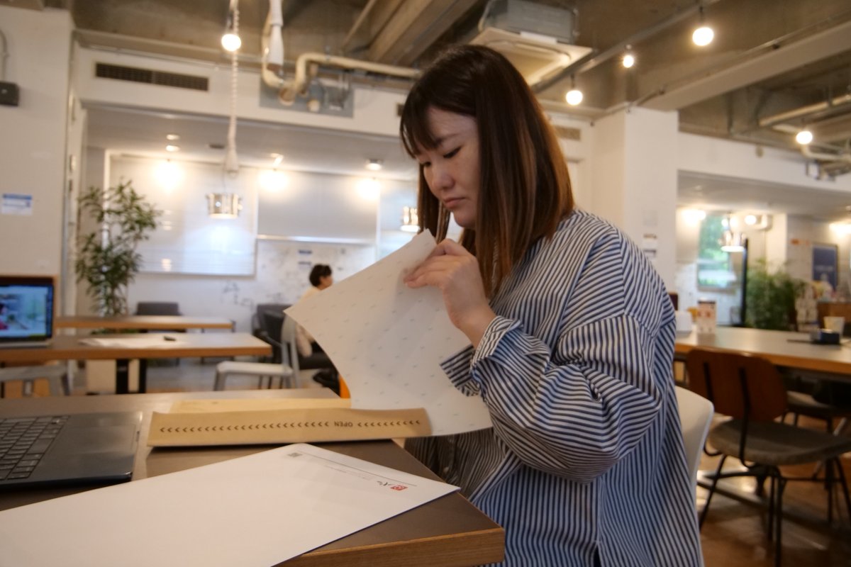 封筒の中身をのぞき込んで確認する高木さん