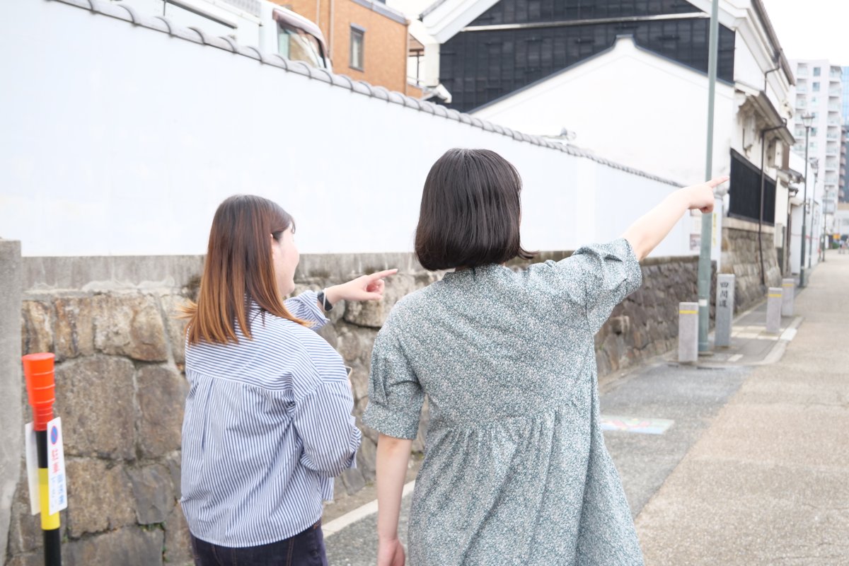 街なかを歩きながらスポット候補を指さして確認する様子