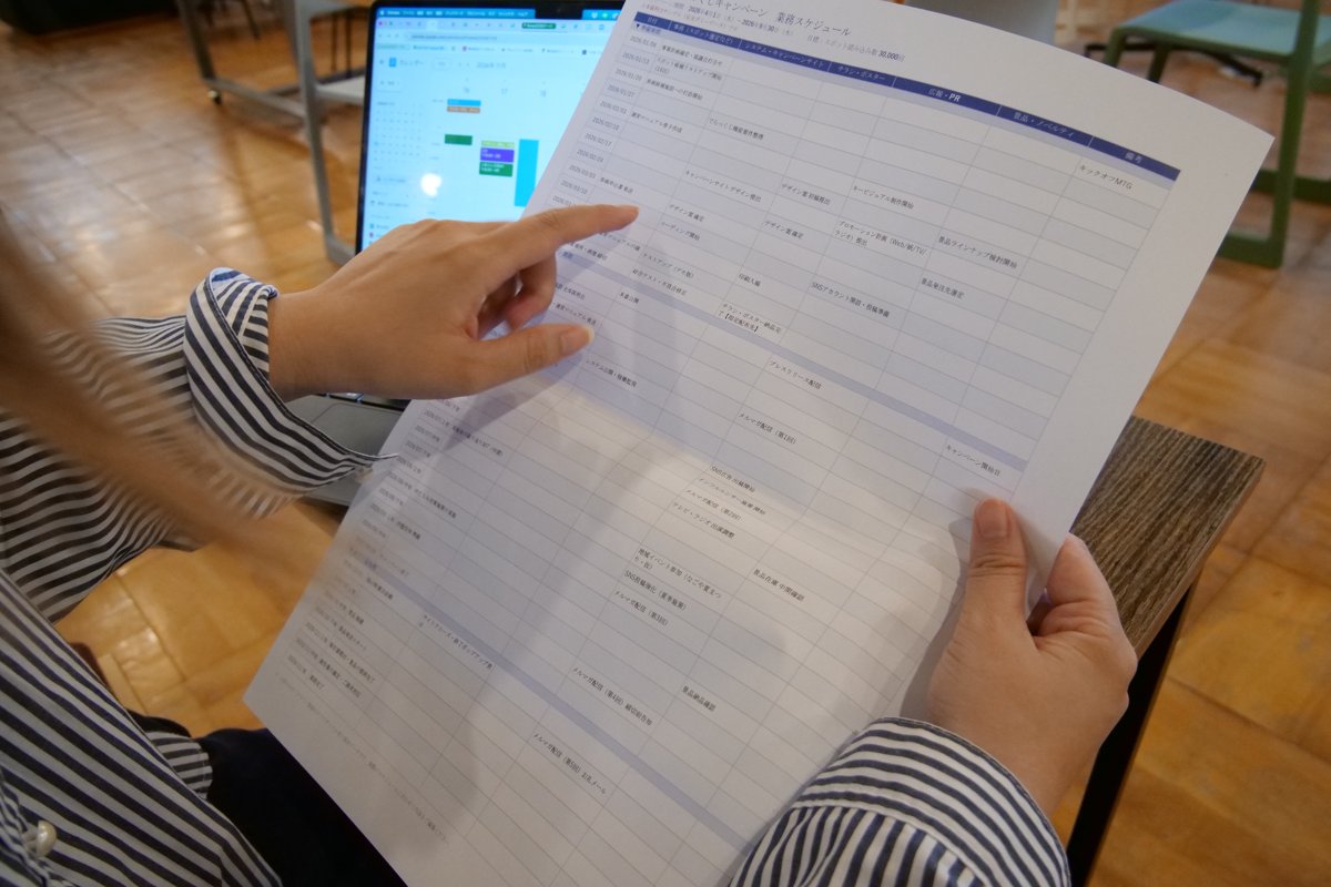 印刷した資料の入力項目を指でたどって確認する様子