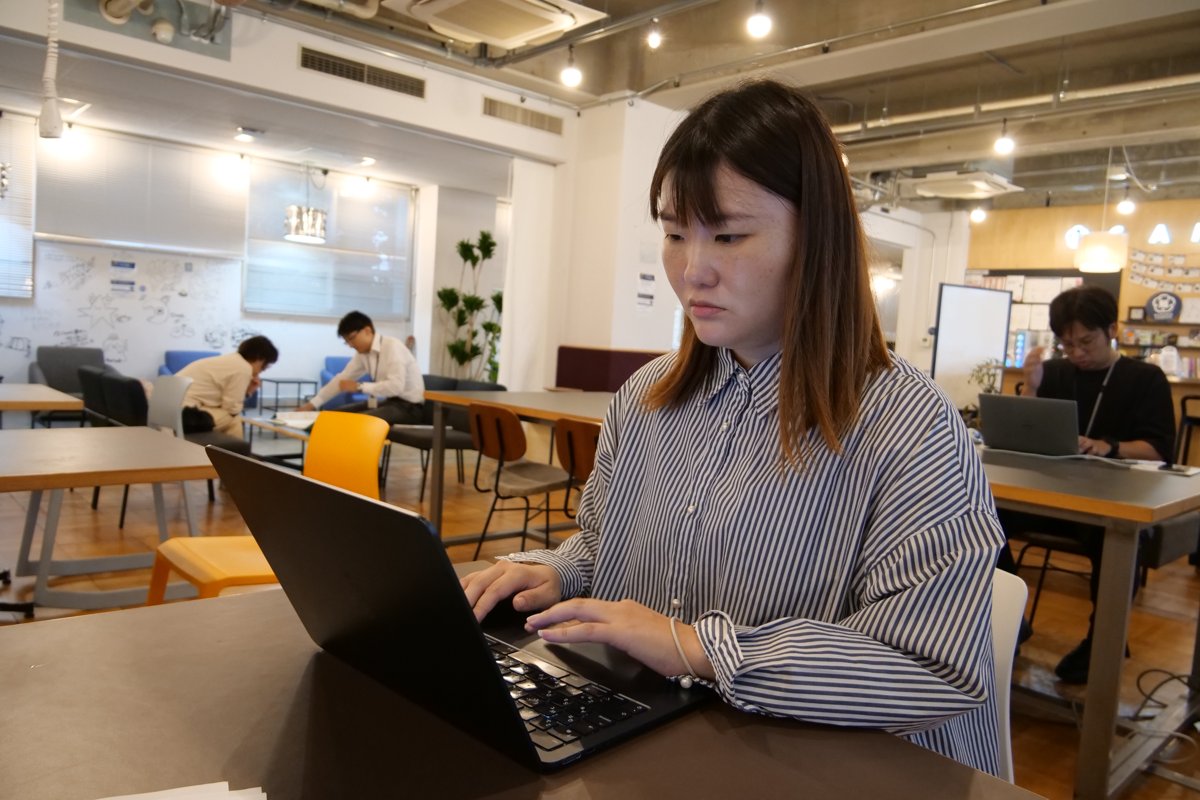 事務所でパソコンに向かって作業する高木さん