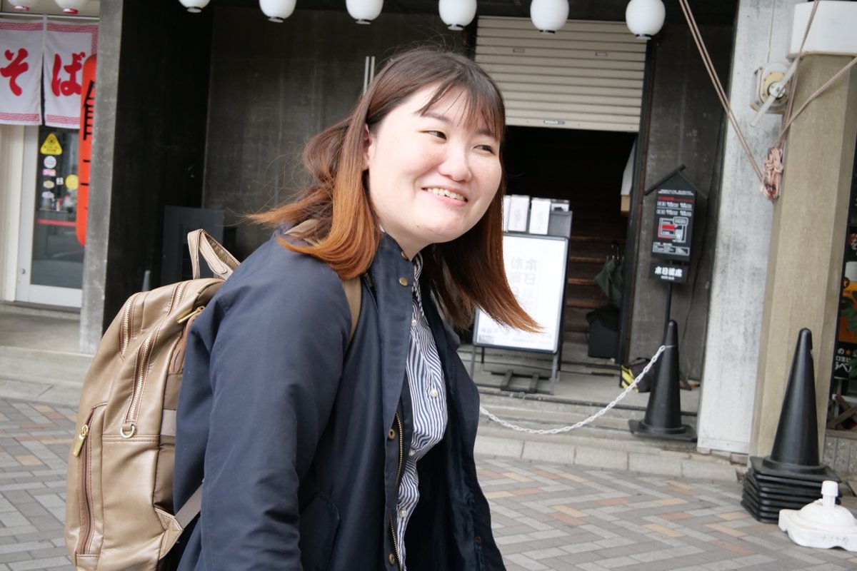 商店街の店先で笑顔を見せる高木さん